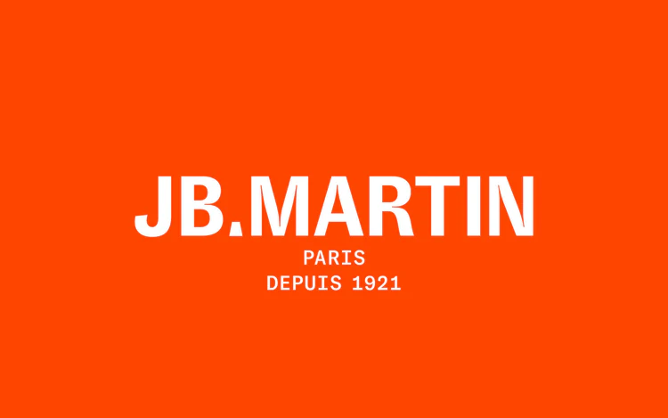 Logo JB Martin blanc sur fond orange vif avec les mentions Paris et depuis 1921.